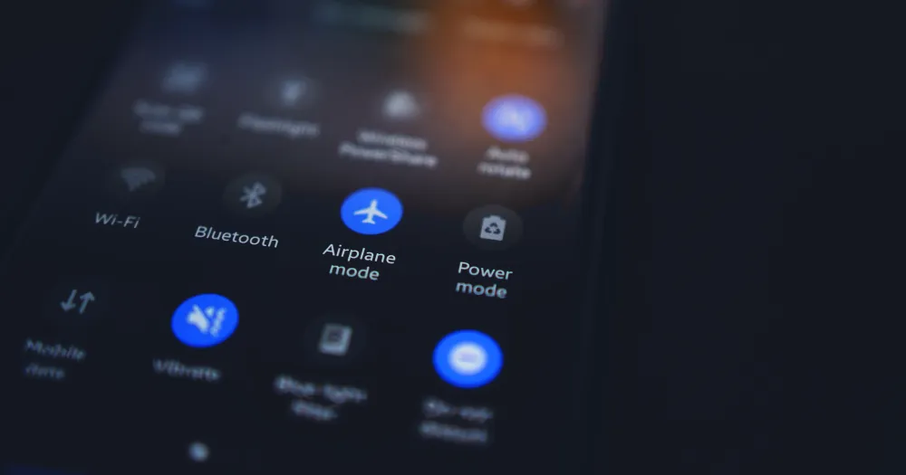 Blurred close-up of a smartphone’s quick settings screen (Wi-Fi, Bluetooth, airplane mode)